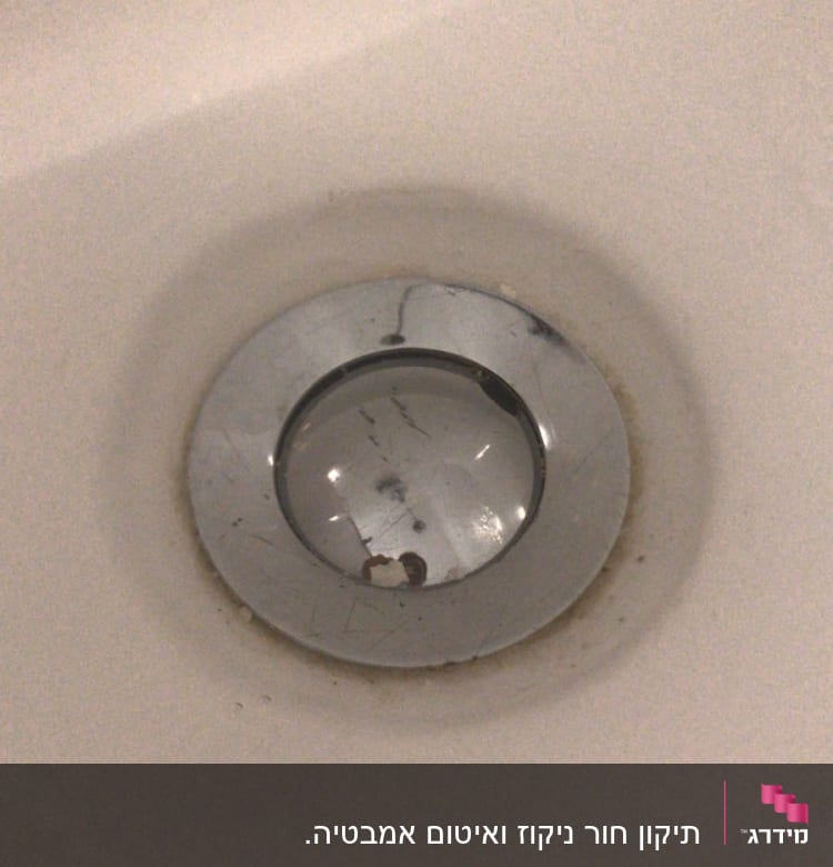 פתח ניקוז מתכת בכיור עם כתמים